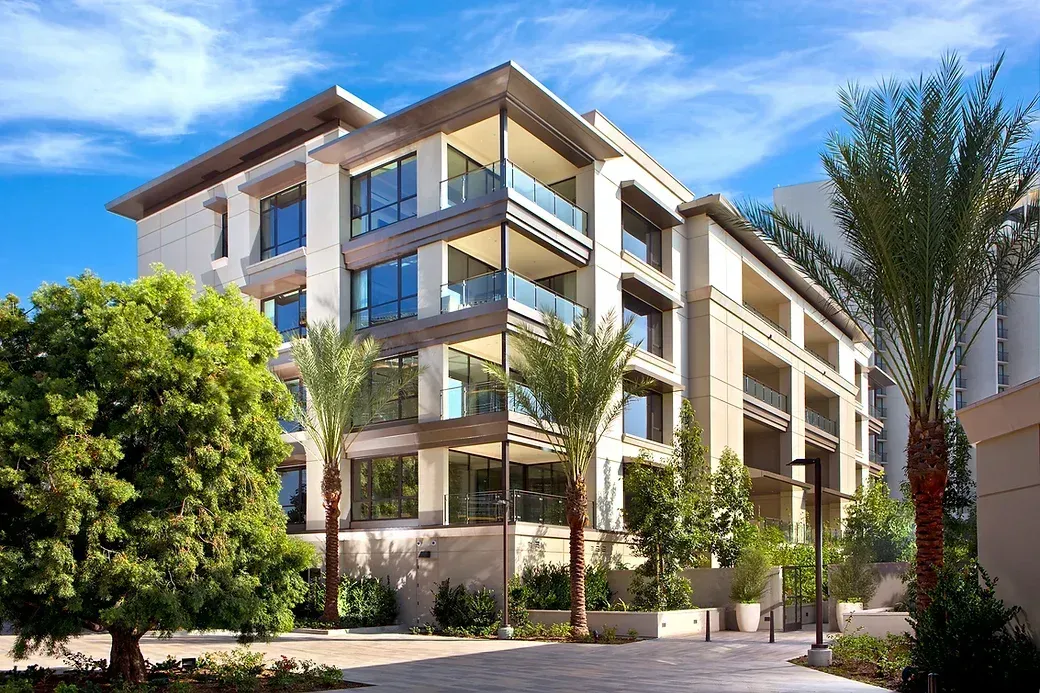 Residential building with palm trees and a blue sky