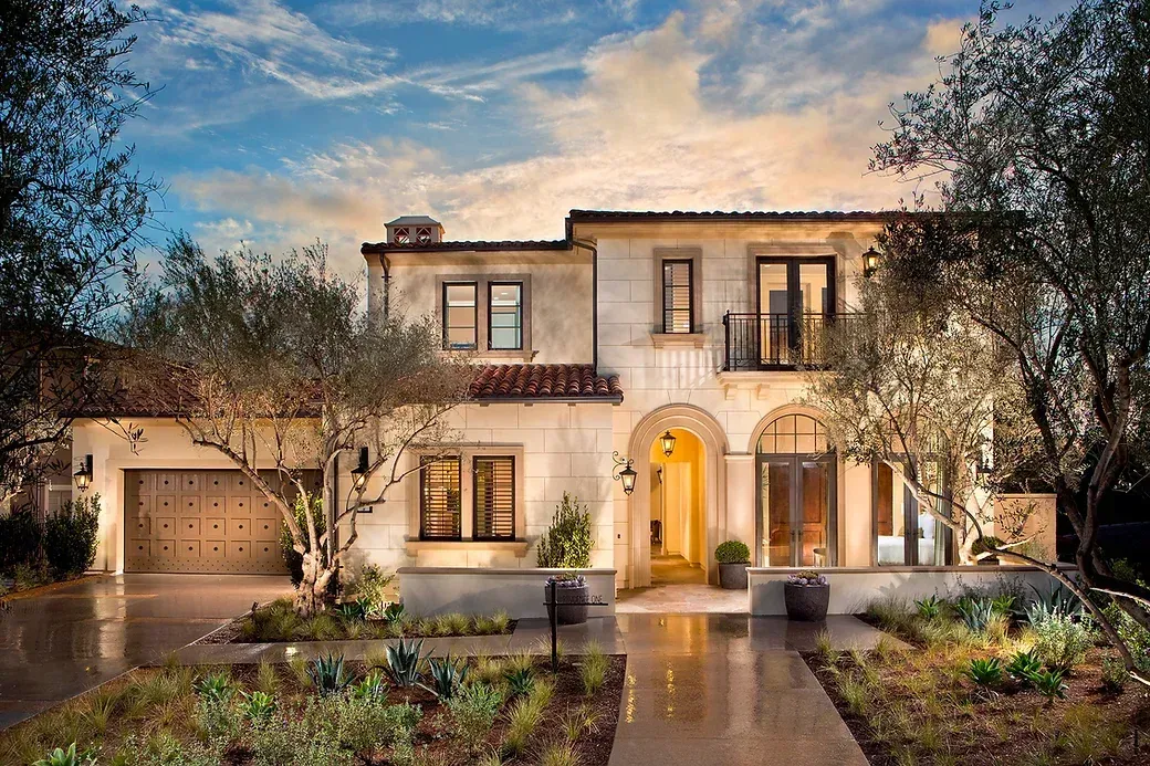 Two-storey home with olive trees at dusk